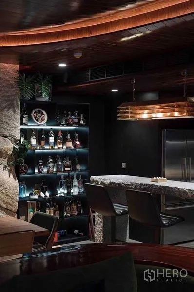 公寓 出租在Watthana, Bangkok - 带灯酒瓶陈列架与双开门冰箱，旁为石面吧台