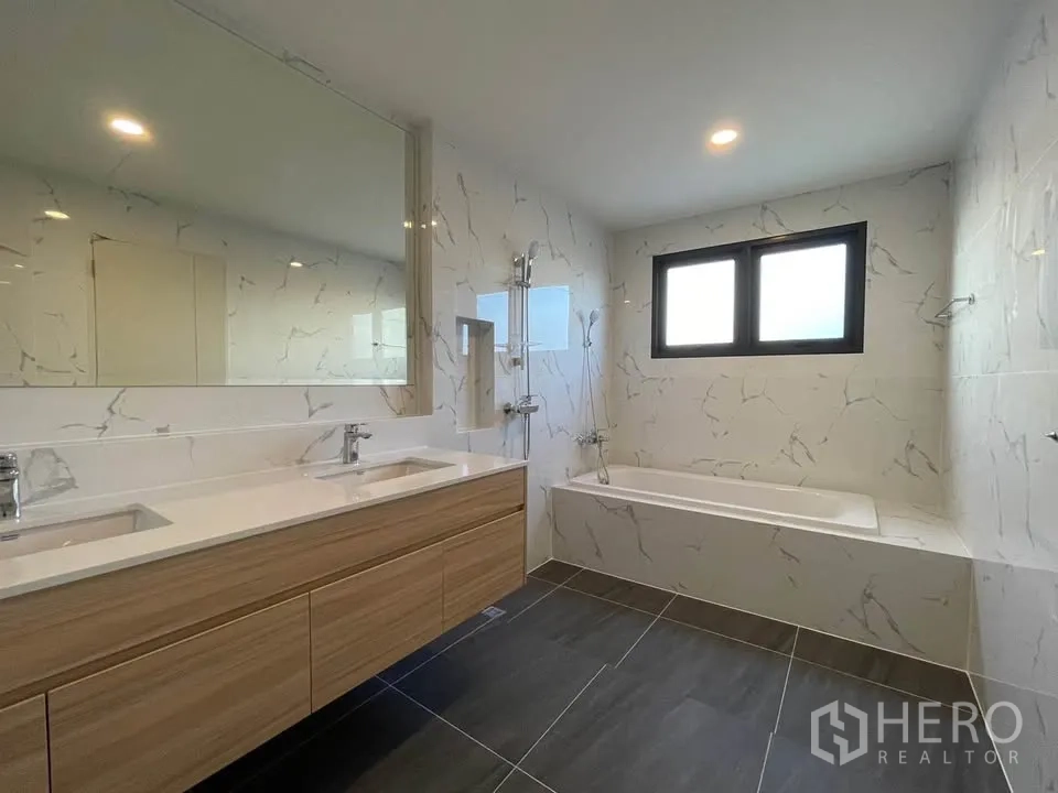 บ้านเดี่ยว for rent or sale in Bang Phli, Samut Prakan - ห้องน้ำมีอ่างล้างหน้าแบบคู่ อ่างอาบน้ำ และผนังลายหินอ่อน