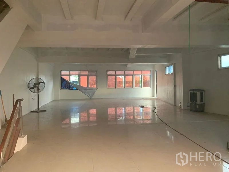 Shophouse for rent in Prawet, Bangkok - Large open workspace with natural light from multiple windows across the facade.