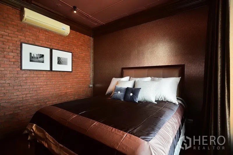 คอนโด ให้เช่าหรือขายในKhlong Toei, Bangkok - ห้องนอนที่สอง ผนังอิฐและผนังสีน้ำตาล เตียงควีนพร้อมหมอนนุ่ม
