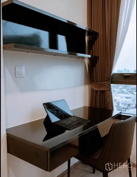 Condominium for sale in Chatuchak, Bangkok - Built-in work desk with shelves and a city view window.