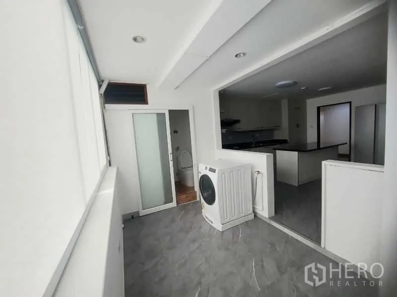 คอนโด ให้เช่าในWatthana, Bangkok - โซนซักล้าง มีเครื่องซักผ้า ประตูบานเลื่อนสู่พื้นที่อเนกประสงค์ พื้นกระเบื้องสีเทา ติดกับครัว