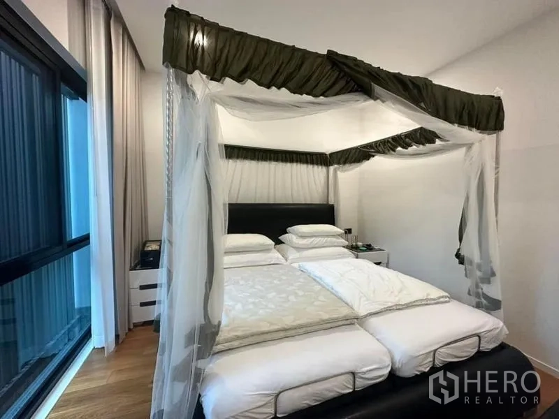 Detached House for sale in Saphan Sung, Bangkok - Guest bedroom with canopy bed positioned beside a large window.