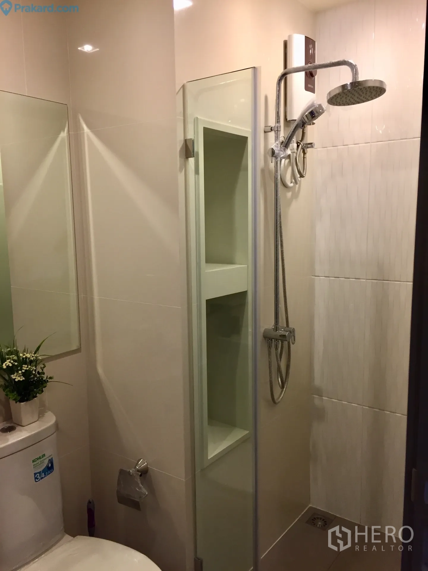 Condominium for rent in Ratchathewi, Bangkok - Contemporary bathroom with glass shower enclosure, rain shower head and toilet.
