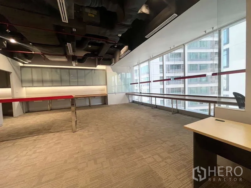 สำนักงาน ให้เช่าในWatthana, Bangkok - โอเพ่นสเปซติดกระจกเต็มบาน เห็นอาคารข้างเคียงและโต๊ะริมหน้าต่าง