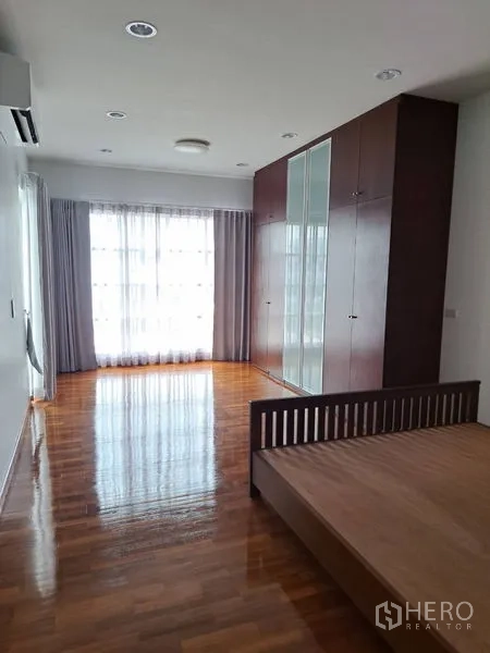 Detached House for rent in Prawet, Bangkok - Spacious master bedroom with built-in wardrobe, hardwood floors and large windows.