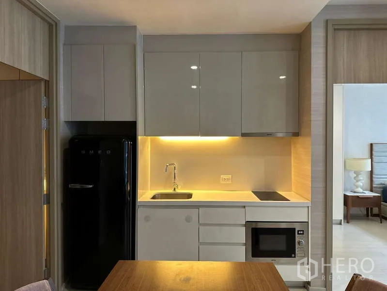 คอนโด ให้เช่าหรือขาย - ครัวแพนทรีดีไซน์เรียบ พร้อมตู้เงา เตา อ่างล้าง และไมโครเวฟ