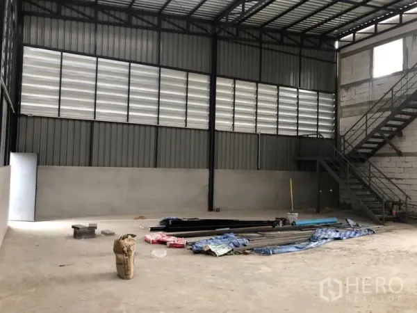 คลังสินค้า ให้เช่าในLam Luk Ka, Pathum Thani - ภายในโกดังโปร่งสูง โครงหลังคาเหล็ก ผนังระบายอากาศ และบันไดเหล็ก
