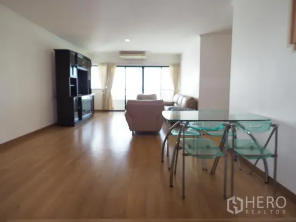 公寓 出租在Sathon, Bangkok - 明亮的客餐厅一体空间，木地板、玻璃餐桌、米色沙发与通往阳台的推拉门，位于曼谷沙吞。