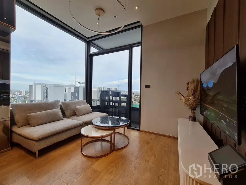 Condominium for rent - Bright living room with sofa and nesting coffee tables opening to balcony and city view.
