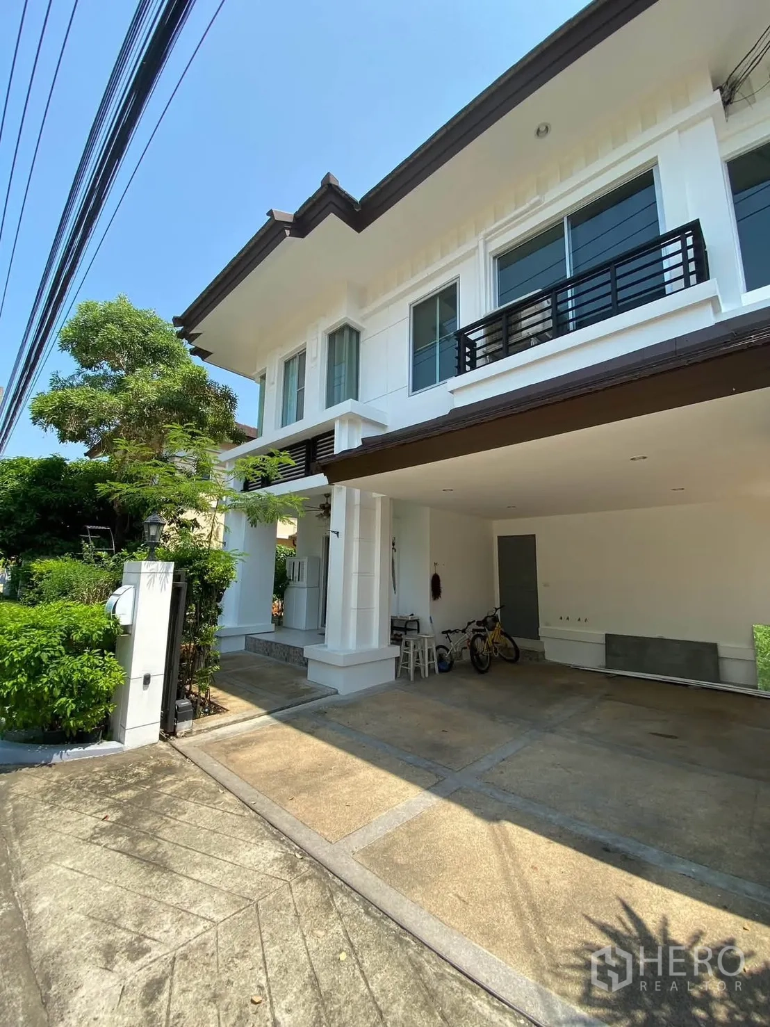 Detached House for rent in Mueang Samut Prakan, Samut Prakan - Two-storey house exterior with covered carport and balcony.