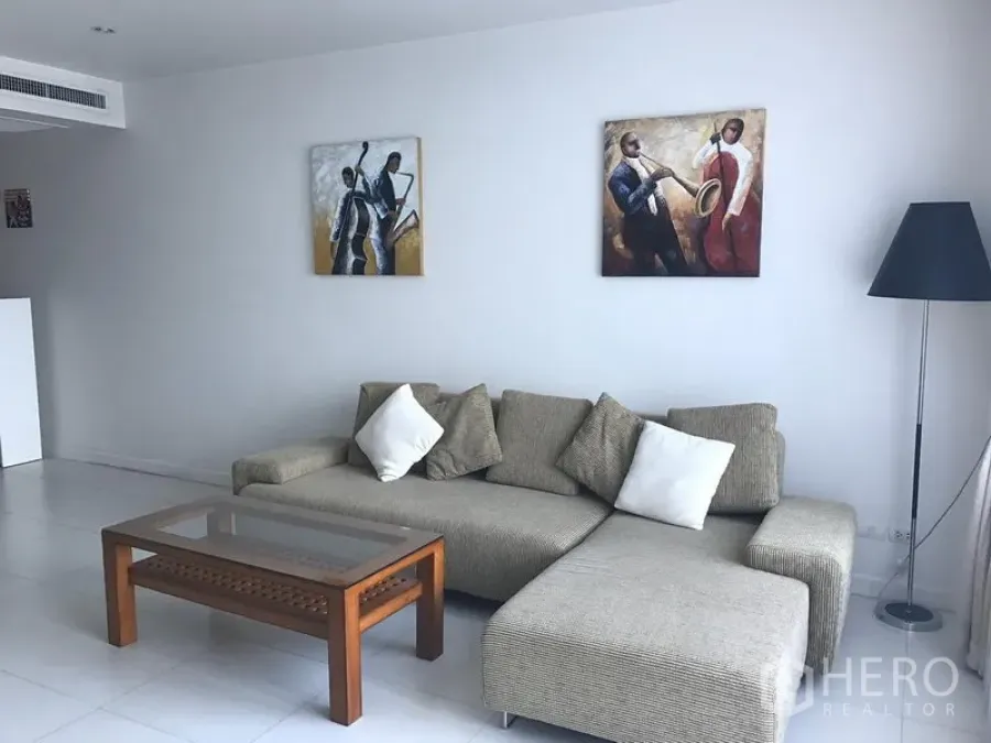 Condominium for rent in Bang Rak, Bangkok - Modern lounge area with sectional sofa, floor lamp and wall art in a Silom condominium.