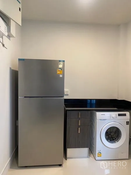 Detached House for rent in Bang Phli, Samut Prakan - Utility area with stainless refrigerator, washing machine and black countertop.