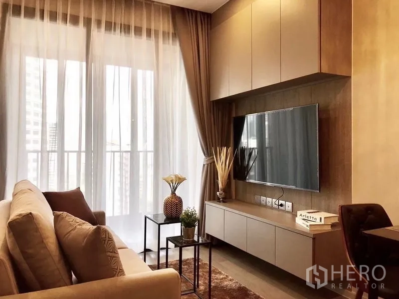 Condominium for rent in Watthana, Bangkok - Living area with TV wall, floating cabinet, and balcony behind sheer curtains.
