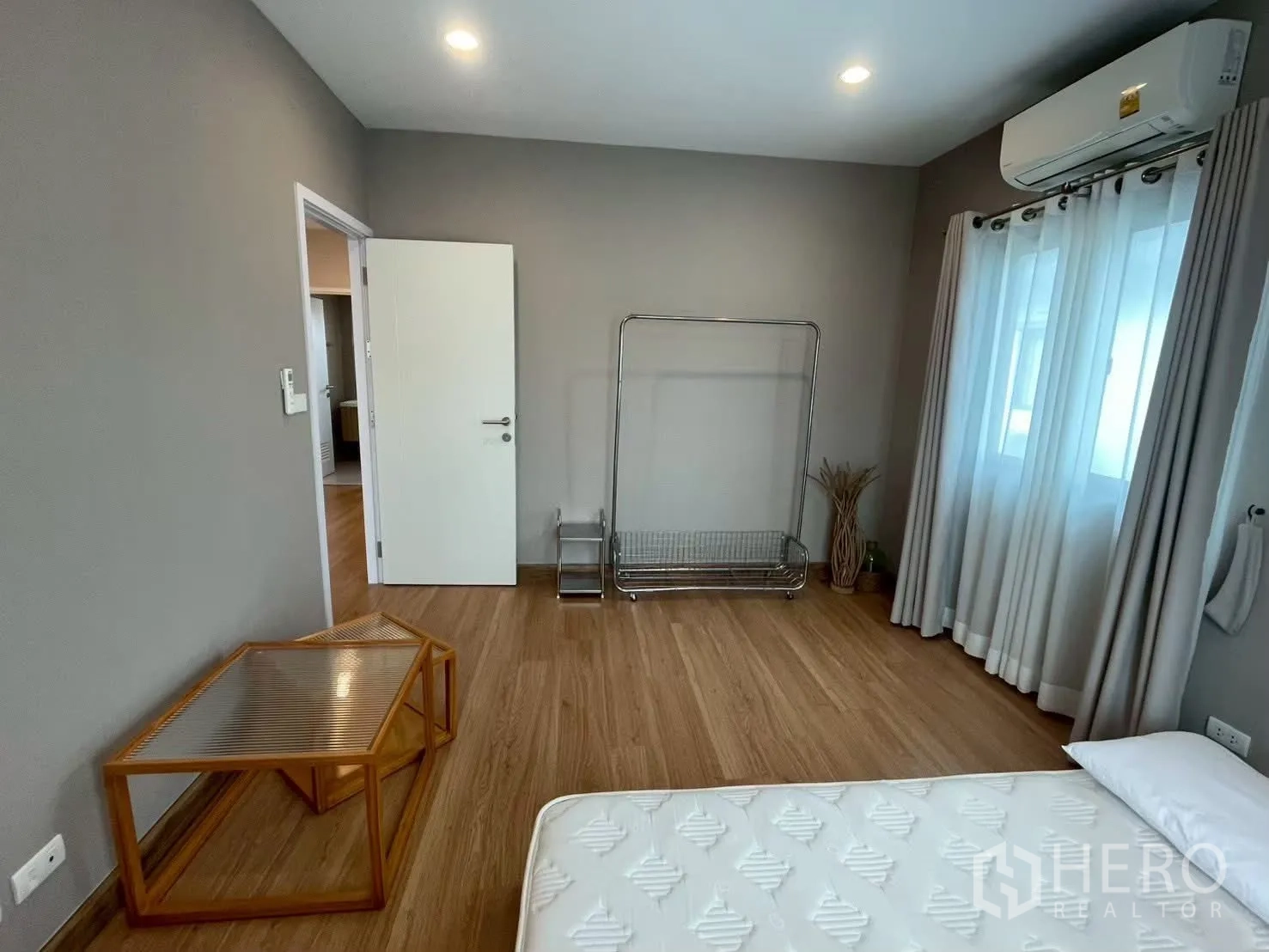 Detached House for rent in Bang Phli, Samut Prakan - Bright bedroom with mattress, air conditioner and a metal garment rack.