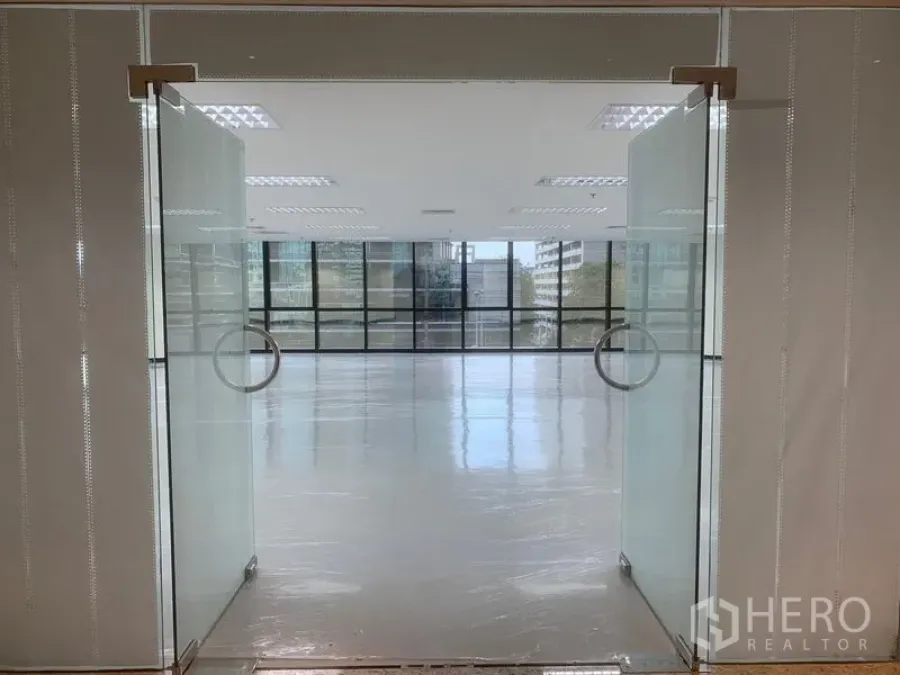 办公空间 出租在Bang Rak, Bangkok - 双开磨砂玻璃门通向采光充足、整面窗的现代办公室。