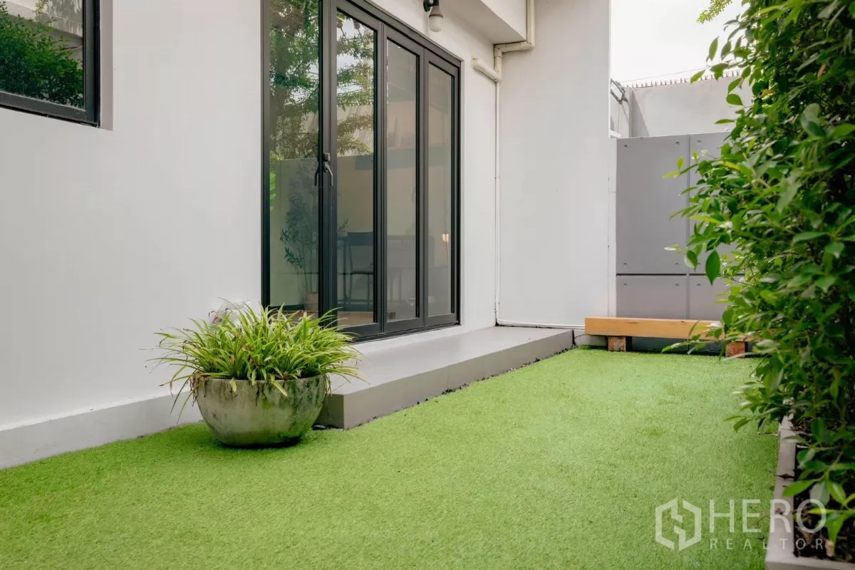 独立式住宅 出租或出售在Bang Phli, Samut Prakan - 私家庭院，人工草坪与通向室内的推拉门。
