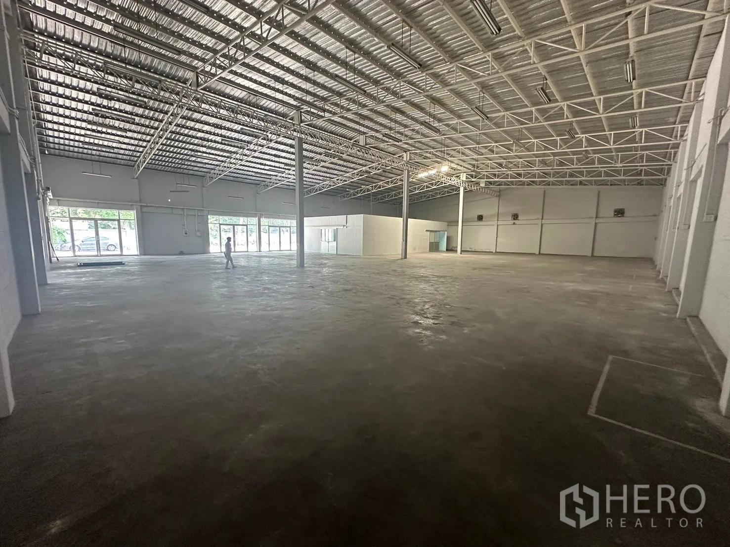 Warehouse for rent in Din Daeng, Bangkok - Expansive warehouse hall with a high steel truss roof and full-height glass frontage.