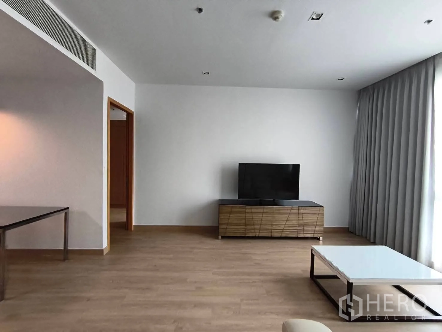 คอนโด ให้เช่าในKhlong Toei, Bangkok - ห้องนั่งเล่นสว่าง ตู้วางทีวีไม้ โต๊ะกลาง และผ้าม่านเต็มความสูงข้างหน้าต่างบานใหญ่