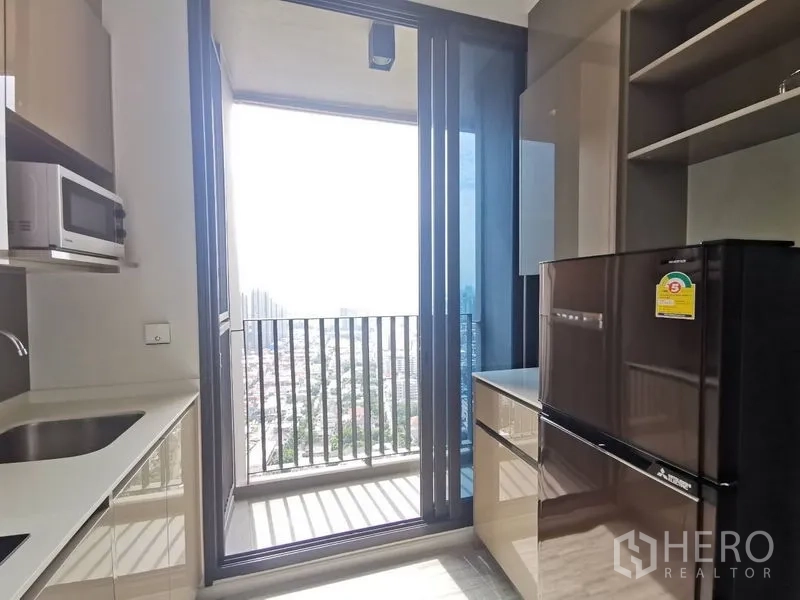 公寓 出售在Phra Khanong, Bangkok - 全配厨房，含微波炉、水槽与大冰箱，通往观景阳台。