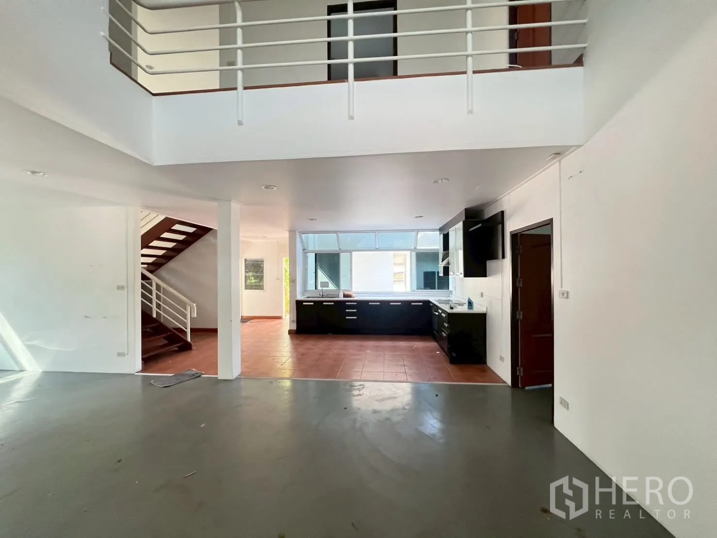 Detached House for rent in Watthana, Bangkok - Open-plan living area with a double-height ceiling leading toward the kitchen.