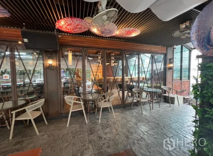 พื้นที่ขายปลีก ให้เช่าในWatthana, Bangkok - ด้านหน้าทางเข้าพร้อมประตูกระจกพับและโต๊ะเล็กใต้กันสาด