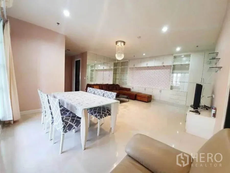 公寓 出租在Ratchathewi, Bangkok - 开放式客餐厅，水晶吊灯，白色餐桌，内置柜与皮质转角沙发。