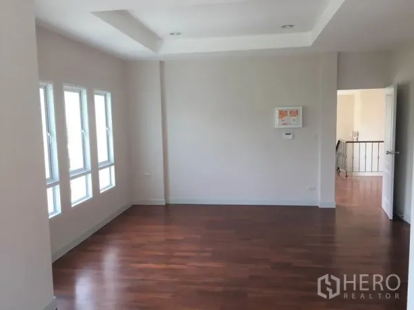Detached House for rent in Saphan Sung, Bangkok - Spacious bedroom with multiple narrow windows, recessed ceiling and timber flooring.