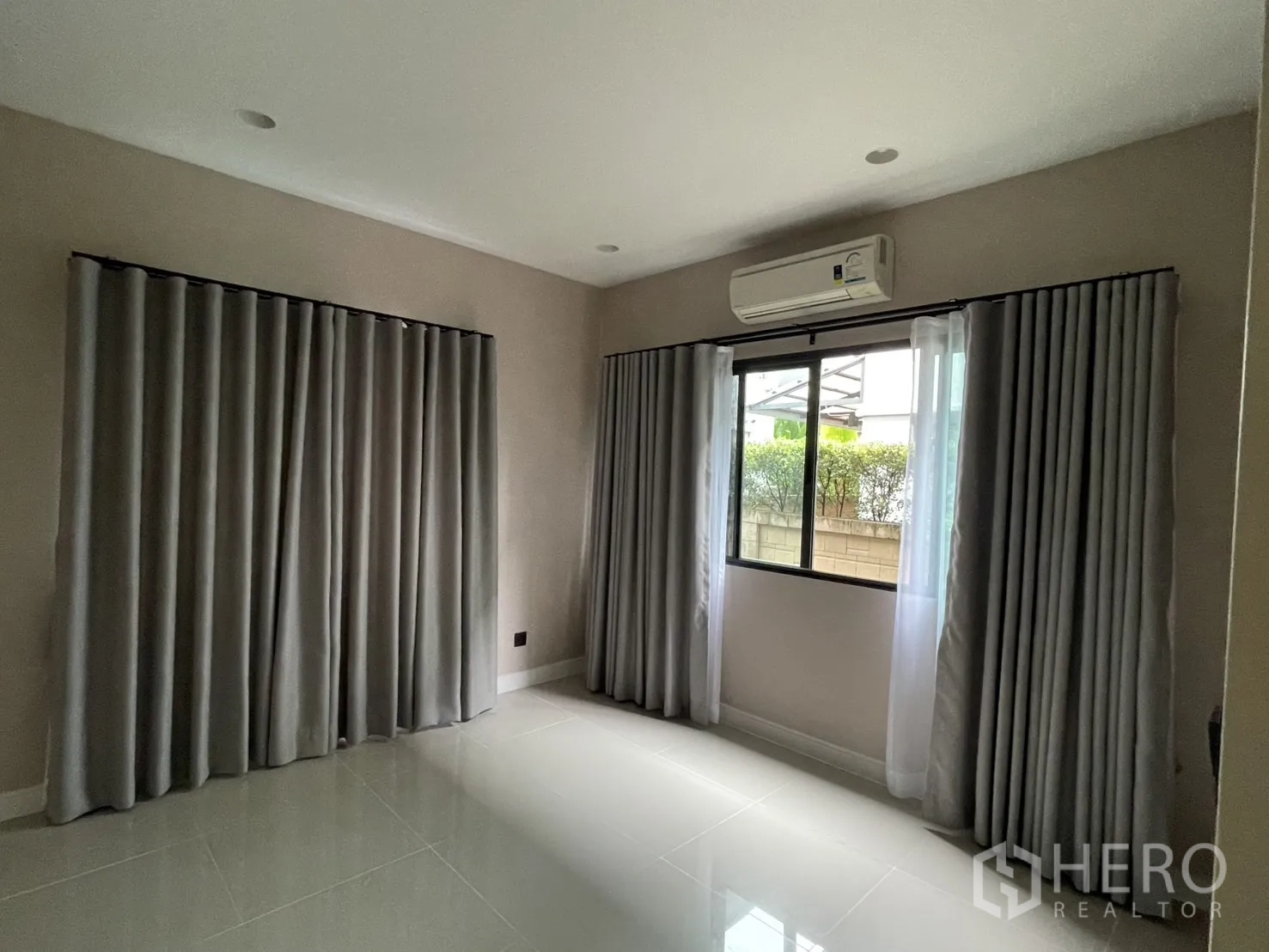 Detached House for rent in Bang Kapi, Bangkok - Ground-floor bedroom with glossy tile floor and double windows.