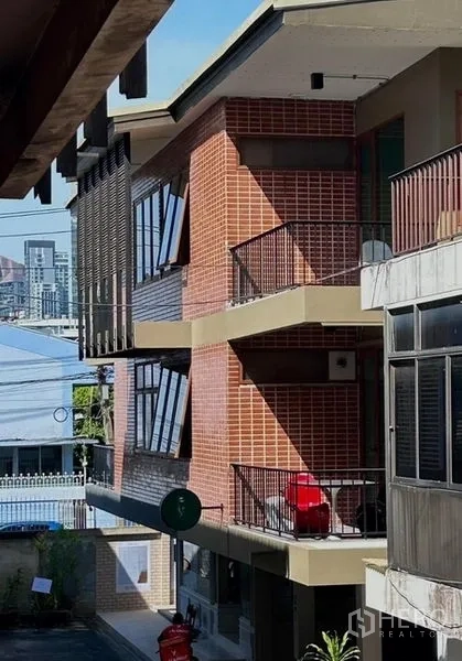 Apartment for rent in Khlong Toei, Bangkok - Low-rise brick apartment exterior with narrow balconies and angled windows in the Thonglor area.