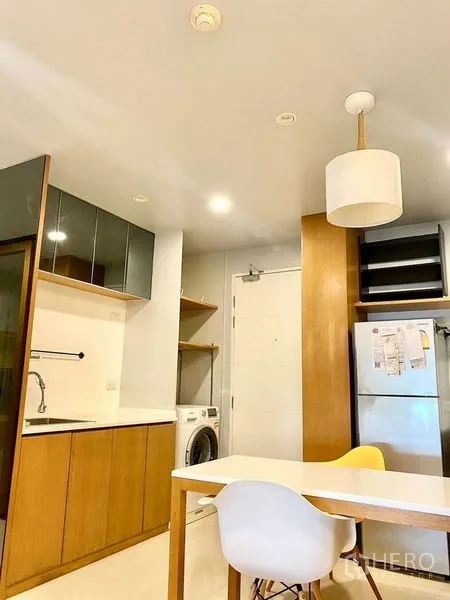 คอนโด ให้เช่าในChatuchak, Bangkok - ครัวเปิดพร้อมตู้ไม้ เคาน์เตอร์สีขาว ตู้เย็น เครื่องซักผ้า และโต๊ะทานข้าว