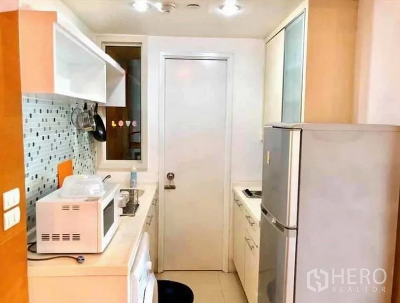 คอนโด ให้เช่าหรือขายในRatchathewi, Bangkok - ครัวแบบแกลลีย์กะทัดรัด ผนังกระเบื้องโมเสก พร้อมเตาอบไมโครเวฟ เตา และตู้เย็น