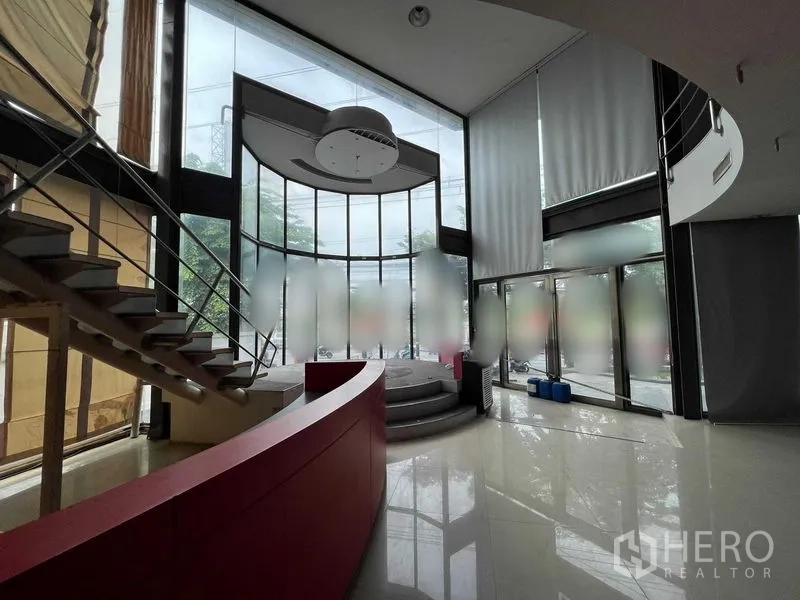 零售空间 出租 - 双层玻璃中庭，红色弧形吧台、通往夹层的楼梯和抬高平台