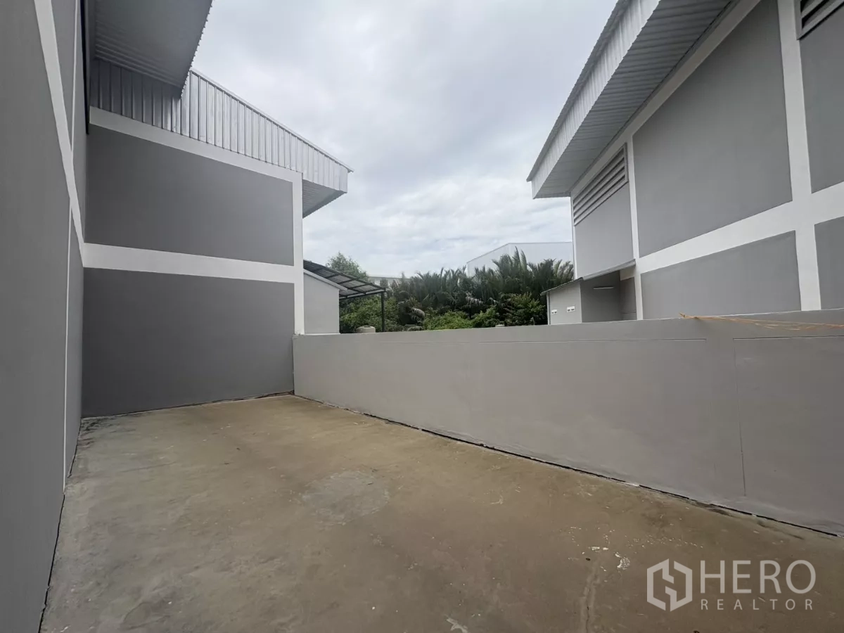 工厂 出租在Phra Samut Chedi, Samut Prakan - 厂房背面的服务庭院，混凝土地坪与矮墙。