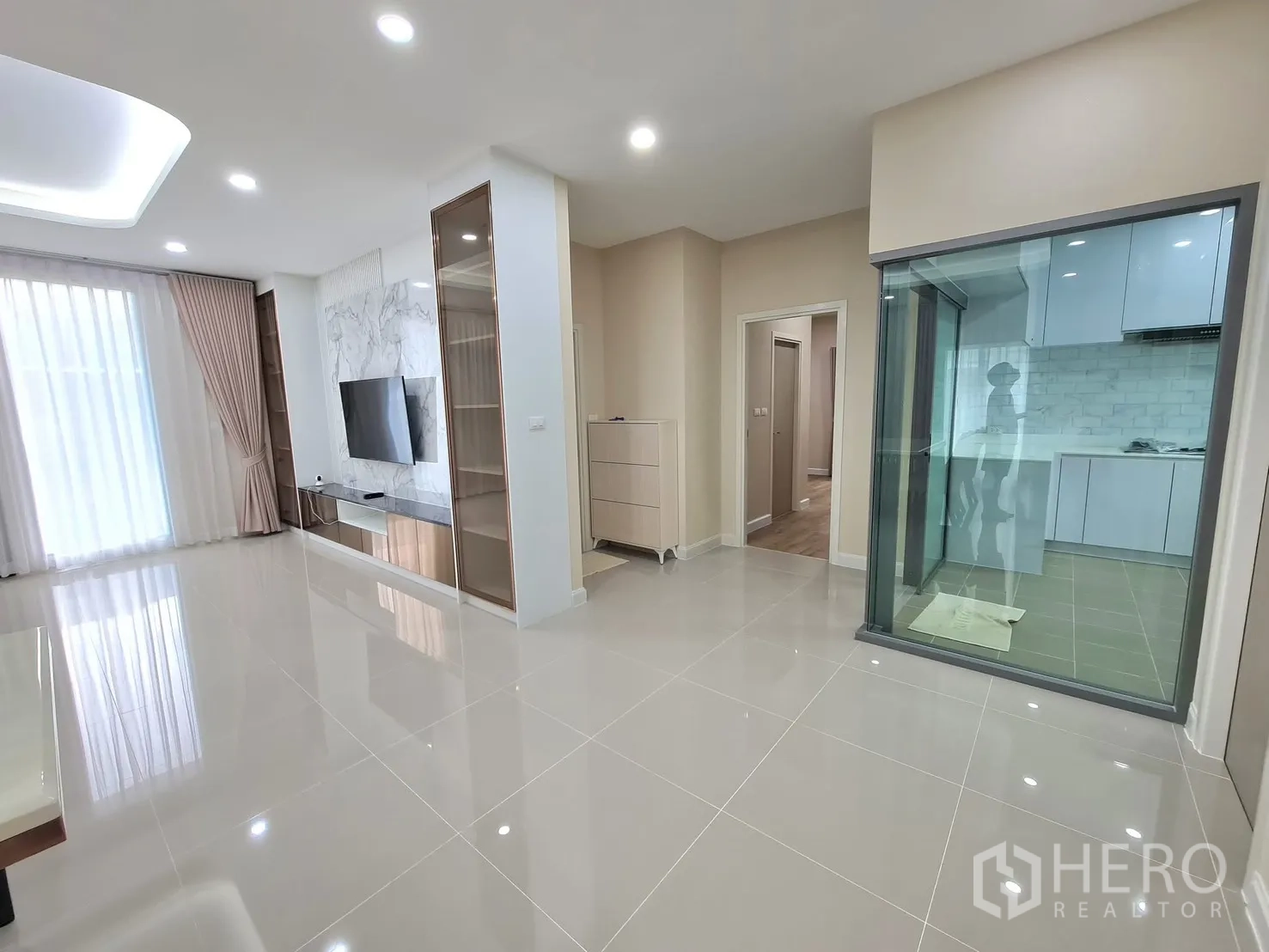 Detached House for rent in Lat Krabang, Bangkok - Bright living room with marble TV wall and sliding door to the kitchen.