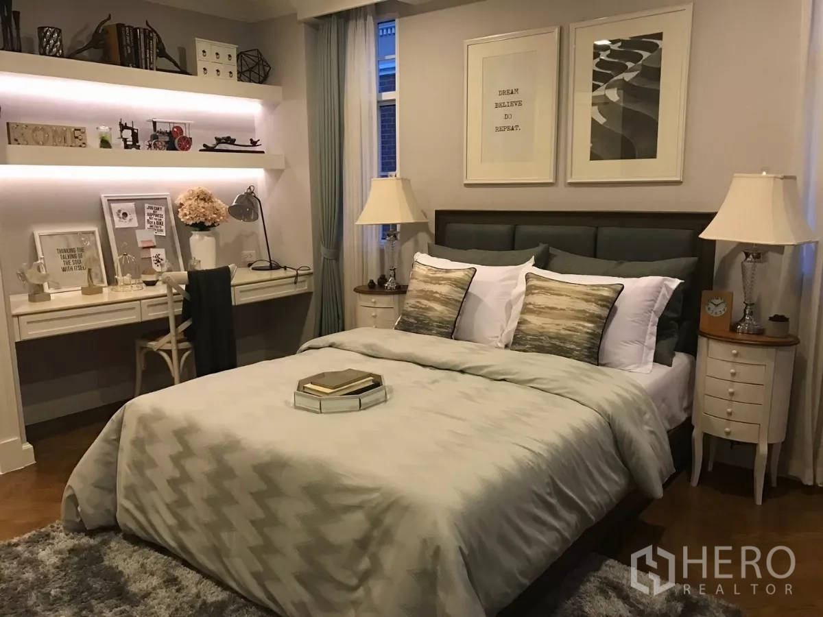 Townhouse for sale in Watthana, Bangkok - Guest bedroom with work desk, illuminated shelves and bedside lamps.