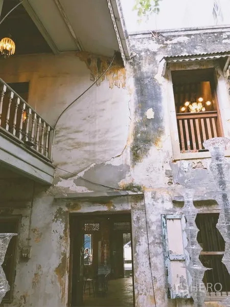 Shophouse for rent in Bang Rak, Bangkok - Two-storey courtyard façade with balcony, timber windows and patinaed walls.