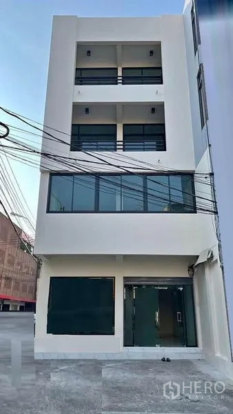 Shophouse for rent in Bang Kapi, Bangkok - Front elevation of a modern four-storey shophouse with balconies and glazing.