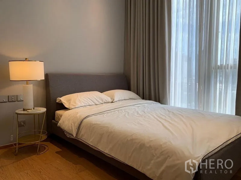 คอนโด ให้เช่าในKhlong Toei, Bangkok - ห้องนอนสว่างเตียงบุนวม โคมไฟหัวเตียง และผ้าม่านทึบโปร่งสองชั้น