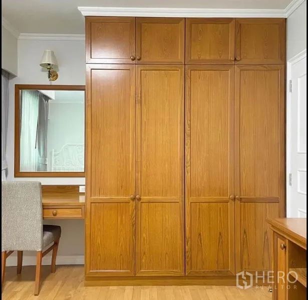 公寓 出租在Sathon, Bangkok - 卧室墙面带内置木质衣柜和梳妆台。