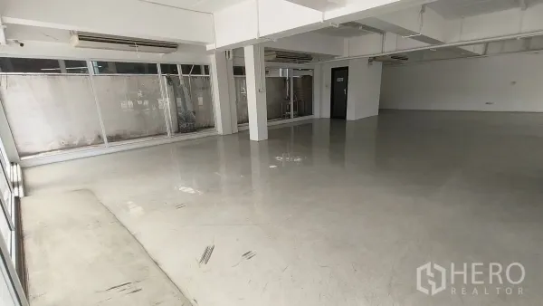 Office Space for rent in Khlong Toei, Bangkok - Open showroom space with floor-to-ceiling windows and structural columns.