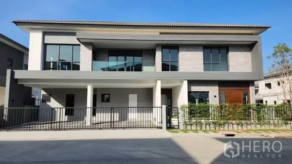 Detached House for rent or sale in Bang Phli, Samut Prakan - Modern two‑storey detached house with wide frontage, balcony, large windows, and gated driveway on a corner plot.