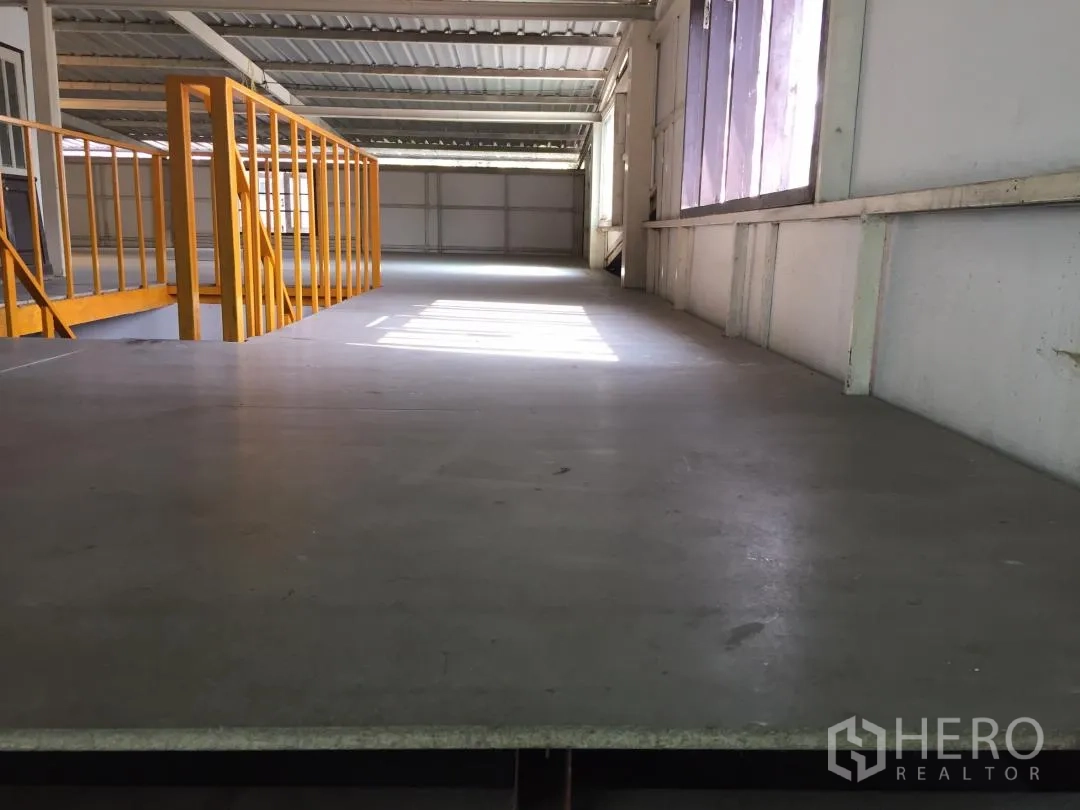 Home Office for rent or sale in Bang Khun Thian, Bangkok - Spacious mezzanine storage level with yellow safety railings and side windows.