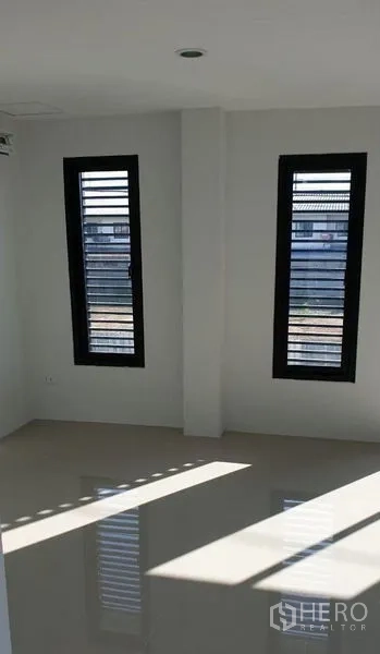 Factory for rent in Lam Luk Ka, Pathum Thani - Sunlit office room with tall narrow windows and polished floor.