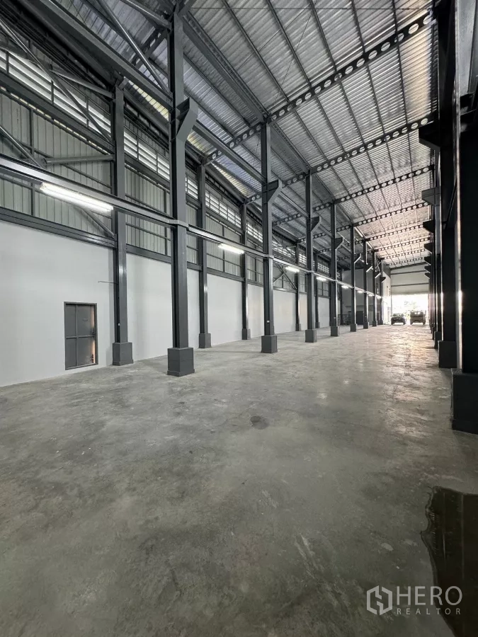 Warehouse for rent in Bang Khun Thian, Bangkok - High-ceiling warehouse interior with steel columns and polished concrete floor.