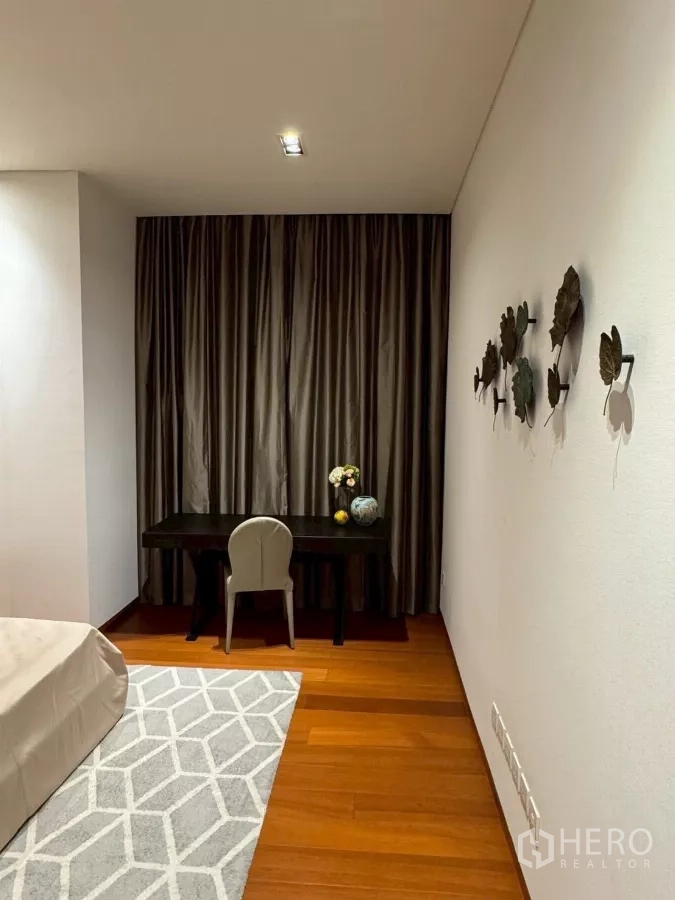 公寓 出租在Sathon, Bangkok - 卧室一角的学习区，深色书桌、座椅与墙面装饰。