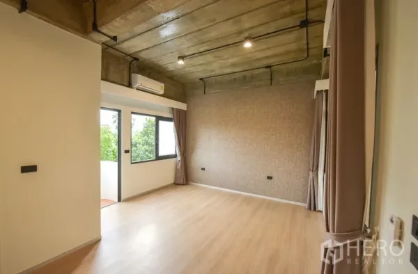 Home Office for rent or sale - Spacious bedroom or office with exposed concrete ceiling, wood flooring and balcony window.