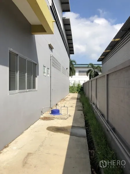 工厂 出租在Pathum Thani - 建筑侧廊，沿墙布置管线与排水沟。