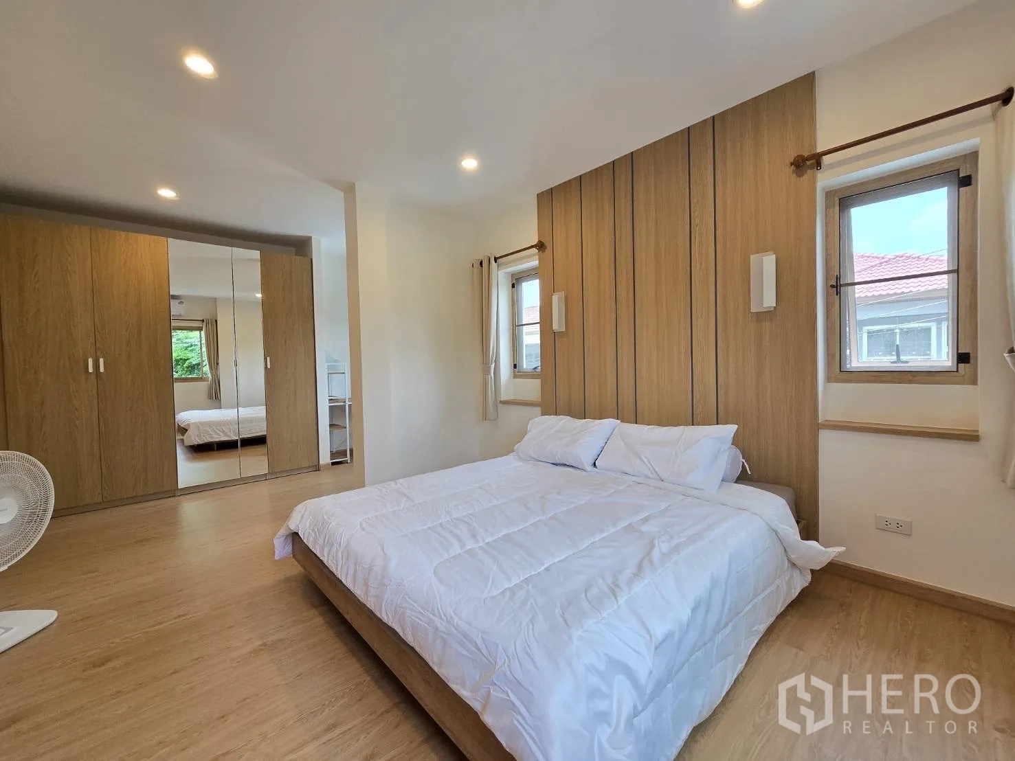 独立式住宅 出售在Suan Luang, Bangkok - 主卧配木质背景墙与镜面衣柜。