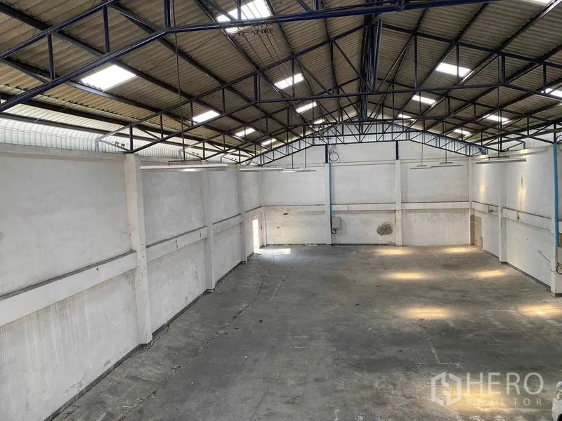 Factory for rent or sale in Bang Phli, Samut Prakan - Large clear-span warehouse hall with high steel truss roof and skylights.